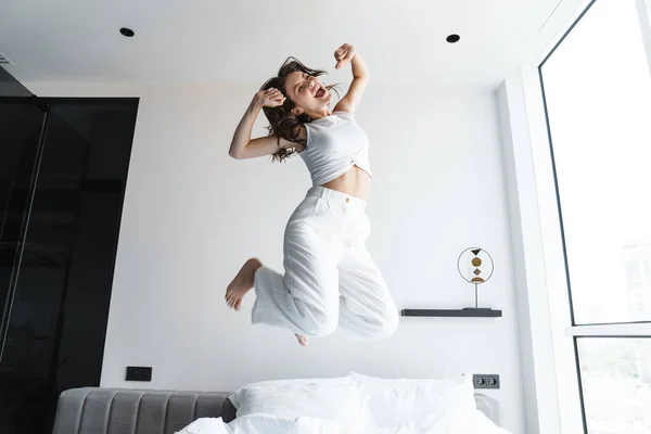 Imagen Joven Mujer Emocionada Burlándose Saltando Cama Casa — Foto de Stock