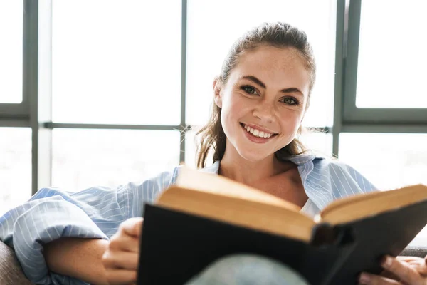 Imagem Uma Jovem Menina Positiva Feliz Casa Sentada Sofá Enquanto — Fotografia de Stock