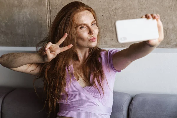 Imagem Mulher Ruiva Gesticulando Sinal Paz Enquanto Toma Selfie Celular — Fotografia de Stock