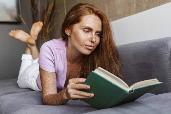 Image Une Femme Rousse Concentrée Lisant Livre Alors Elle Était — Photo