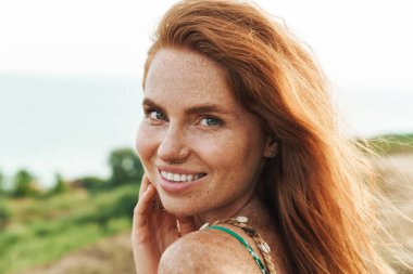 Gün batımında çayırda yürüyen, yaz elbisesi giymiş güzel bir kız. Yaklaş.