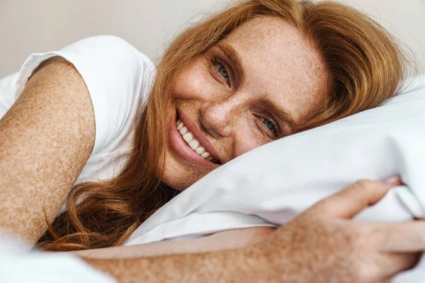 Obraz Rudej Szczęśliwej Kobiety Piegami Uśmiechniętymi Kamery Leżącej Łóżku Domu — Zdjęcie stockowe