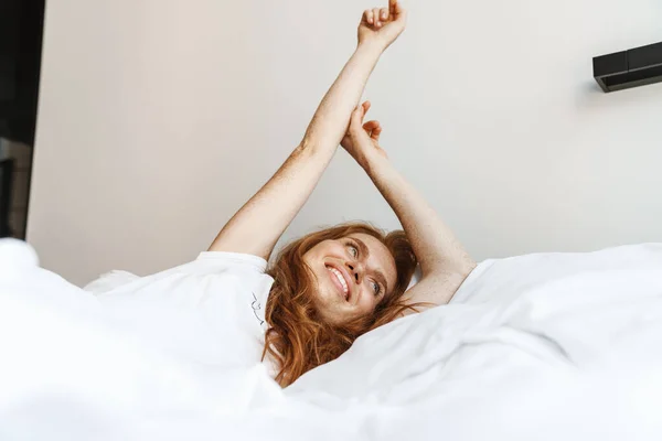 Obraz Rudej Szczęśliwej Kobiety Piegami Rozciągającymi Jej Ciało Leżąc Łóżku — Zdjęcie stockowe