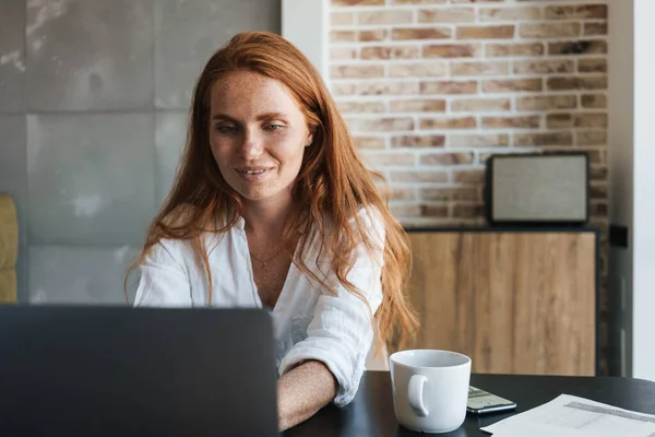 Bilde Smilende Rødhåret Forretningskvinne Som Jobber Med Laptop Mens Hun – stockfoto