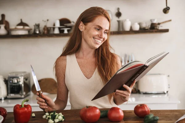 Imagem Mulher Gengibre Feliz Tendo Leitura Livro Culinária Enquanto Prepara — Fotografia de Stock