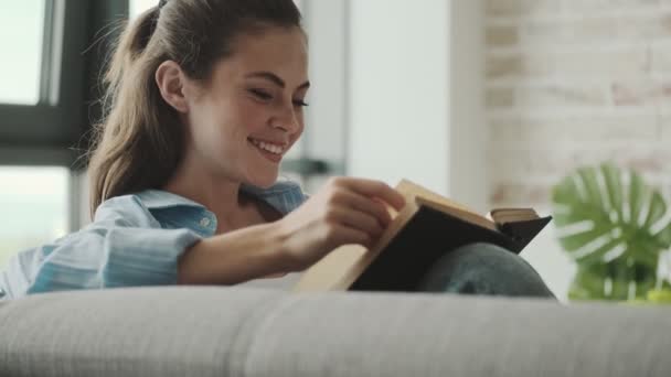 Egy Gyönyörű Fiatal Könyvet Olvas Otthon — Stock videók