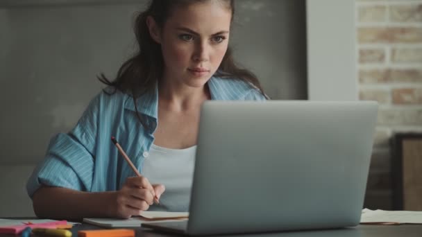 Μια Συγκεντρωμένη Νεαρή Γυναίκα Δουλεύει Έγγραφα Χρησιμοποιώντας Τον Φορητό Υπολογιστή — Αρχείο Βίντεο