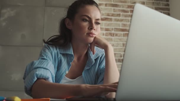 Een Aantrekkelijke Jonge Vrouw Zet Haar Oordopjes Terwijl Het Werken — Stockvideo