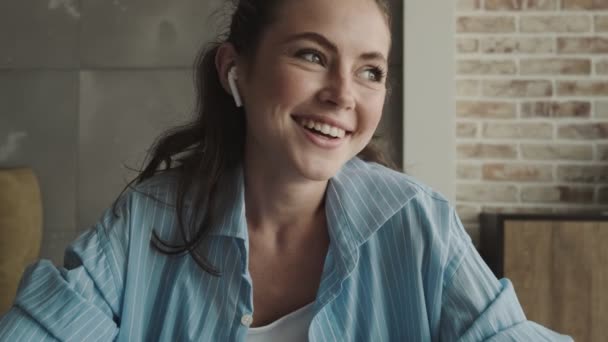 Una Joven Sonriente Con Auriculares Tiene Una Conversación Línea Usando — Vídeos de Stock