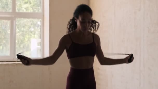 Молодая Африканская Фитнес Сконцентрированная Женщина Прыгает Скакалкой Белом Фоне — стоковое видео