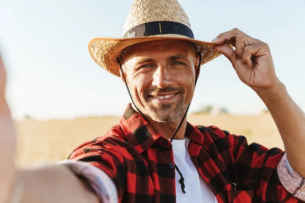 Obraz Zadowolonego Dorosłego Mężczyzny Słomkowym Kapeluszu Robiącego Selfie Polu Zbóż — Zdjęcie stockowe