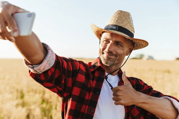Изображение Довольного Взрослого Мужчины Соломенной Шляпе Делающего Селфи Мобильному Телефону — стоковое фото