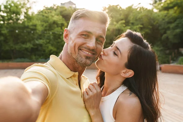 幸せな中年のカップルの男と女の肖像写真を撮り 夏の公園を歩きながらキス — ストック写真