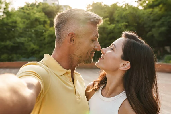夏の公園を歩いている間に ロマンチックな中年のカップルの男性と女性の自撮り写真と抱擁の肖像 — ストック写真