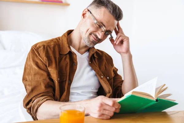 Bild Stilig Nöjd Man Glasögon Läser Bok Och Ler När — Stockfoto