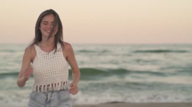 Güzel bir genç kız sahilde koşuyor.