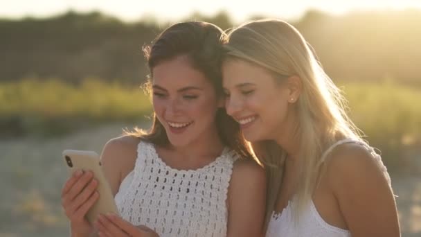 Vista Lateral Duas Meninas Felizes Estão Olhando Fotos Smartphone Andando — Vídeo de Stock