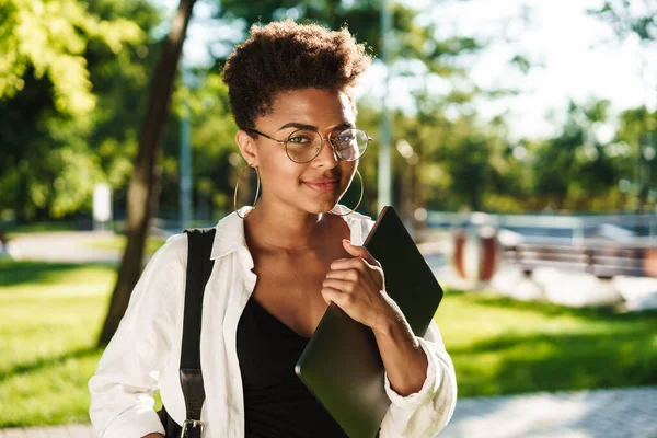 Obrázek Optimistické Africké Ženy Kráčející Venku Parku Při Držení Notebooku — Stock fotografie