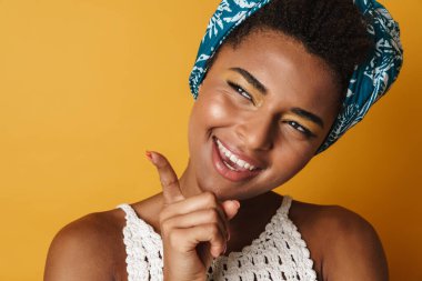 Mutlu Afro-Amerikan kadın görüntüsü gülümseyen ve işaret eden izole edilmiş sarı arka plan