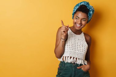 Mutlu Afro-Amerikan kadın görüntüsü gülümseyen ve işaret eden izole edilmiş sarı arka plan