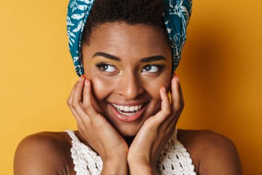 Kamerada poz veren ve gülen komik Afrikalı Amerikalı kadın görüntüsü izole edilmiş sarı arka plan