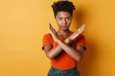 Ciddi bir Afrikalı Amerikalı kadının görüntüsü kamerada izole edilmiş sarı arka plan