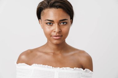 Beyaz arka planda izole edilmiş, poz veren ve kameraya bakan güzel Afrikalı Amerikalı kadın.