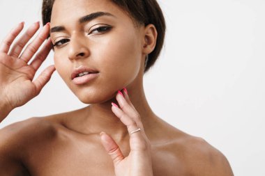 Beyaz arka planda izole edilmiş, poz veren ve kameraya bakan yarı çıplak Afrikalı Amerikalı kadın.