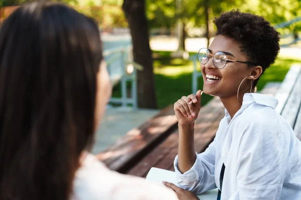 아프리카 출신의 긍정적 여성이 친구와 야외에서 공원에서 대화를 나누면서 — 스톡 사진