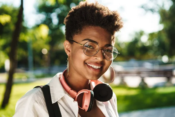 Çekici Afrikalı genç kız parkta yürüyor.