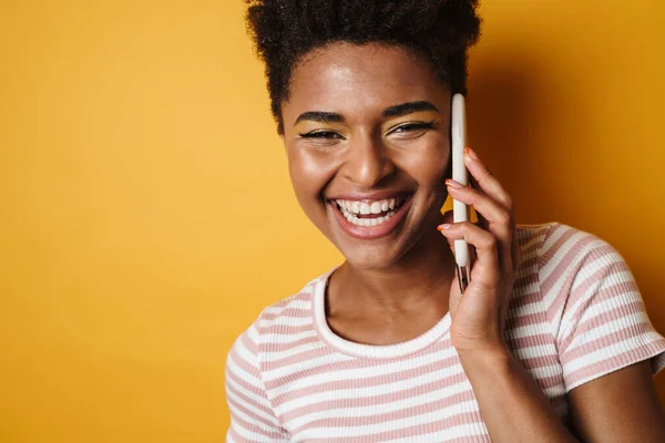 Изображение Веселой Африканской Женщины Смеющейся Разговаривающей Мобильному Телефону Изолированном Желтом — стоковое фото