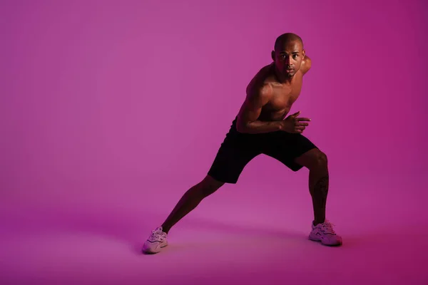 一个英俊而集中的非洲健美运动员被隔离在粉红的墙壁背景下的形象 — 图库照片