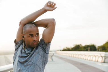 Rahat Afrikalı sporcu köprüde dikilirken geriniyor.