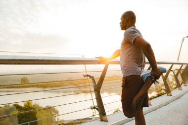 Rahat Afrikalı sporcu köprüde dikilirken geriniyor.