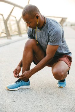 Köprüde bağcıklarını bağlayan Afrikalı sporcu.