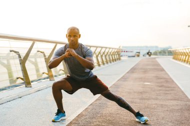 Rahat Afrikalı sporcu köprüde dikilirken geriniyor.