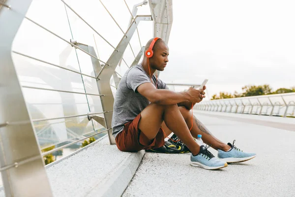 Αφροαμερικάνος Αθλητής Που Ακούει Μουσική Και Χρησιμοποιεί Κινητό Τηλέφωνο Εξωτερικούς — Φωτογραφία Αρχείου
