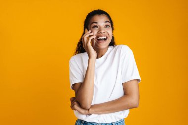 Sarı arka planda konuşan mutlu Afro-Amerikalı kadın.