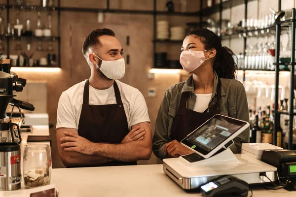 Coffee shop owners with face masks, lockdown, quarantine, coronavirus, back to normal concept