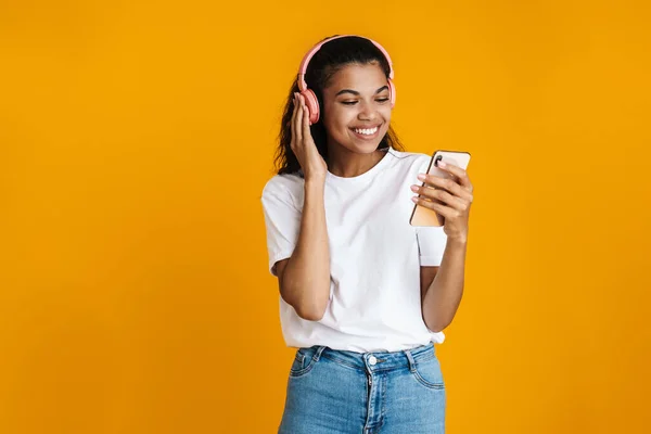 Leende Afrikansk Kvinna Lyssnar Musik Och Använder Smartphone Över Gul — Stockfoto