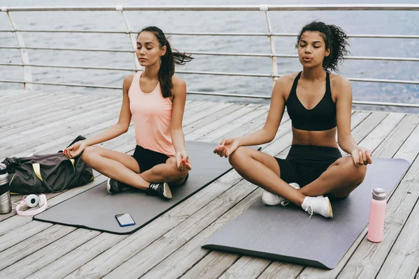 Imagem Mulheres Desportivas Multinacionais Calmas Meditando Enquanto Sentadas Tapetes Passeio — Fotografia de Stock