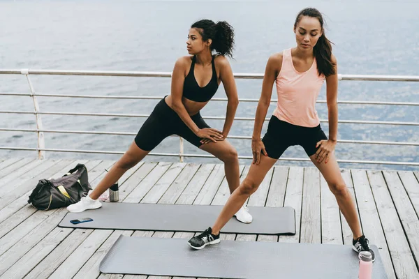 Bild Fokussierter Multinationaler Sportlerinnen Beim Training Auf Matten Der Promenade — Stockfoto