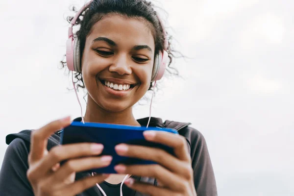 Imagen Una Mujer Afroamericana Sonriente Usando Teléfono Celular Auriculares Mientras —  Fotos de Stock