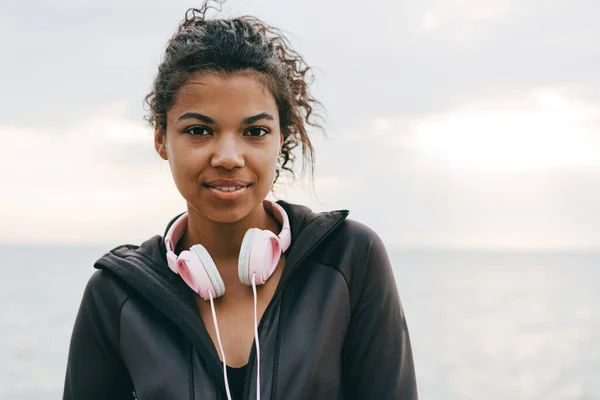 산책로를 걷다가 헤드폰을 채웃고 아프리카계 미국인젊은 여성의 — 스톡 사진