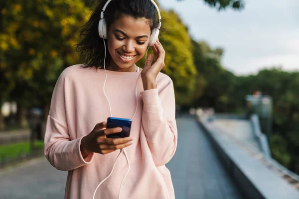 Képek Mosolygó Afro Amerikai Lányról Aki Mobiltelefont Fejhallgatót Használ Séta — Stock Fotó