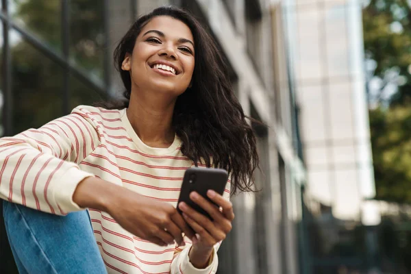 Imagen Niña Afroamericana Sonriente Usando Teléfono Móvil Mientras Está Sentada — Foto de Stock