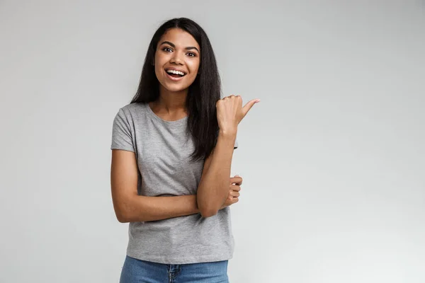 Glimlachende Jonge Afrikaanse Vrouw Draagt Casual Kleding Wijzend Naar Kopieerruimte — Stockfoto