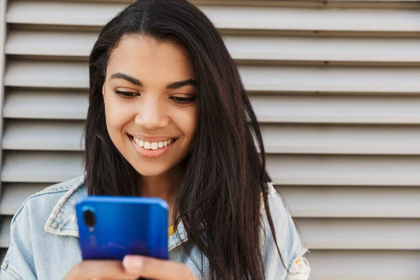 Imagen Alegre Mujer Afroamericana Sonriendo Usando Teléfono Inteligente Mientras Está — Foto de Stock