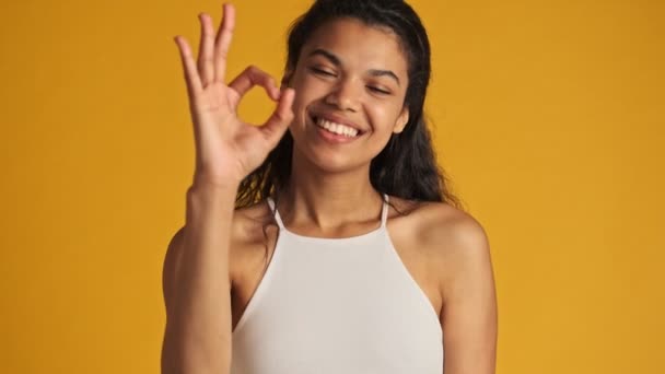 Крупный План Счастливой Молодой Женщины Показывает Жест Стоящий Изолированно Желтом — стоковое видео