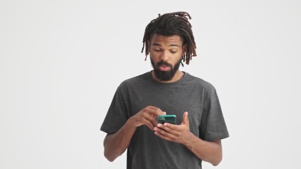 Молодой Африканский Улыбающийся Мужчина Изолирован Белом Фоне Стены Помощью Мобильного — стоковое видео